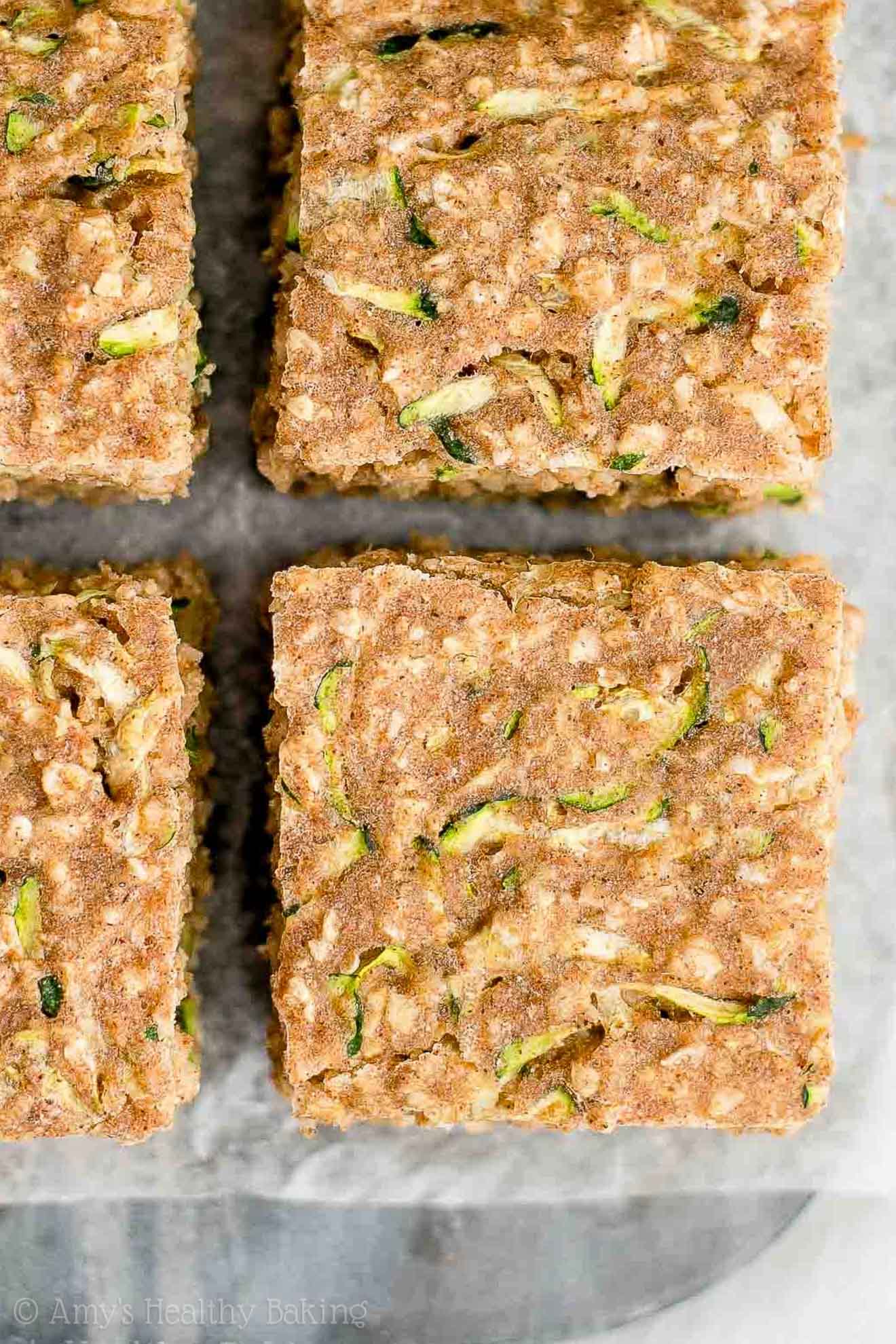 close-up overhead view of square slices of healthy zucchini oatmeal snack cake – easy recipe for a healthy zucchini cake full of oats and spices – low calorie, low fat, soft, moist, and clean eating with whole wheat and gluten free options – made with greek yogurt, pure maple syrup, and no refined sugar