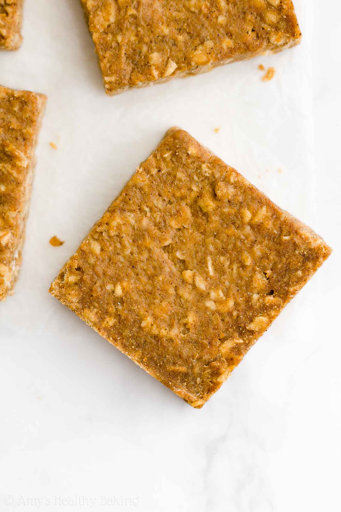 healthy pumpkin oatmeal bars on a white marble countertop – easy oat bars recipe for breakfasts and snacks – vegan, gluten free, egg free, dairy free, and clean eating with whole wheat and gluten free options – made with oats, pumpkin, spices, and no refined sugar