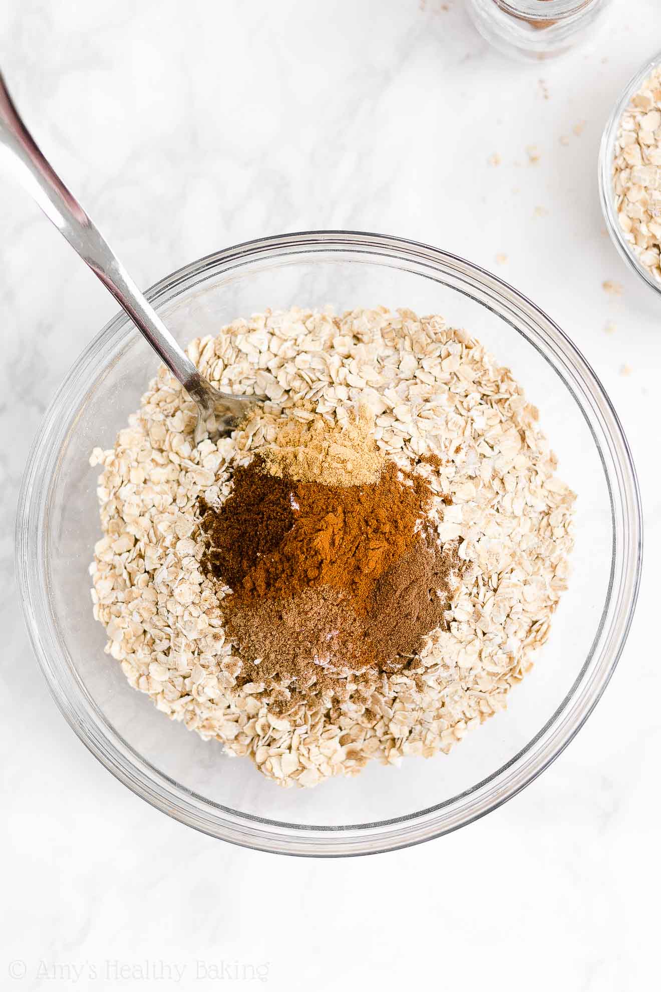 glass mixing bowl holding a fork and the dry ingredients used to make healthy pumpkin oatmeal bars – easy oat bars recipe for breakfasts and snacks – vegan, gluten free, egg free, dairy free, and clean eating with whole wheat and gluten free options – made with oats, pumpkin, spices, and no refined sugar