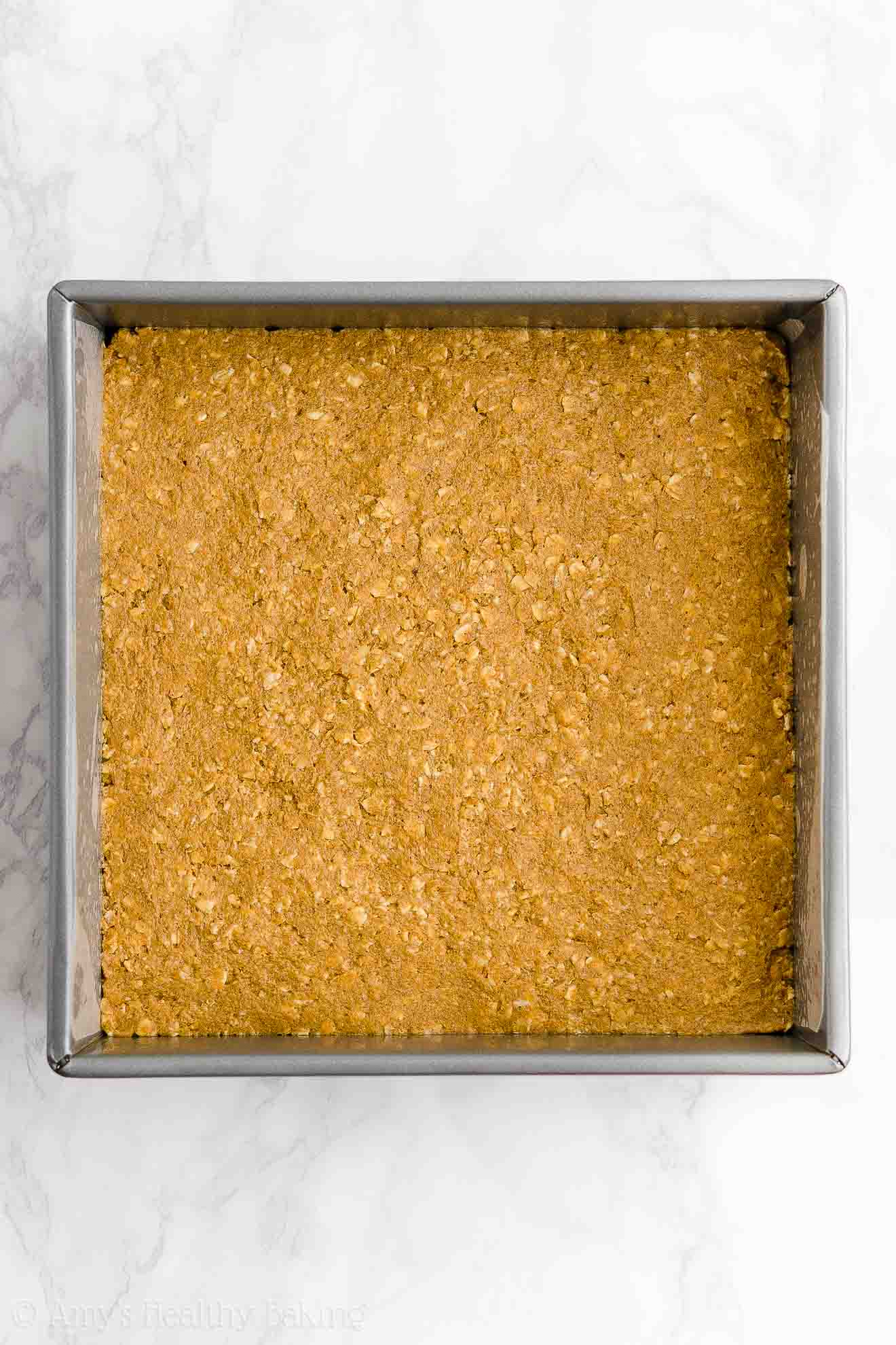 square baking pan holding the mixture used to make healthy pumpkin oatmeal bars – easy oat bars recipe for breakfasts and snacks – vegan, gluten free, egg free, dairy free, and clean eating with whole wheat and gluten free options – made with oats, pumpkin, spices, and no refined sugar
