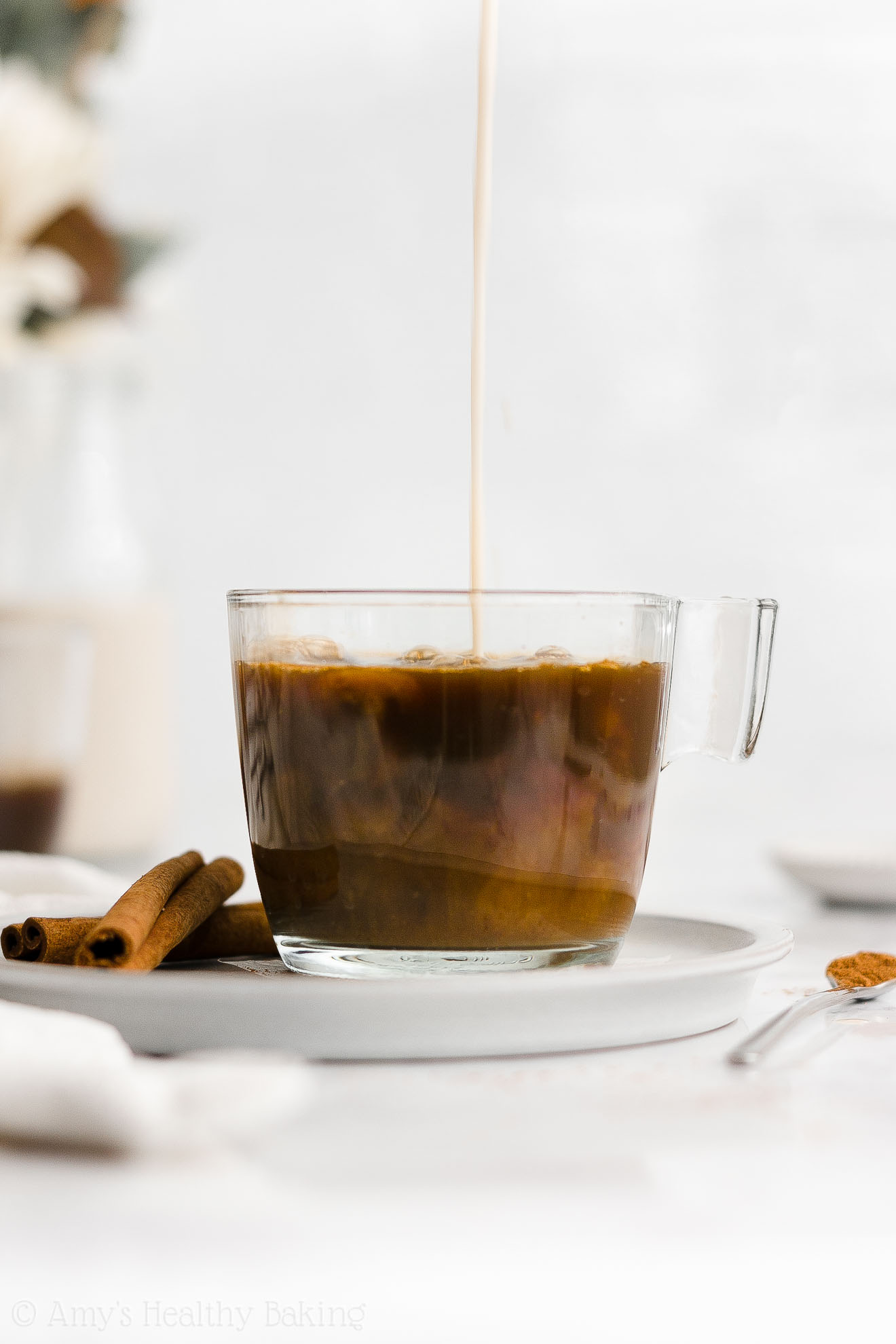 sugar free gingerbread coffee creamer being poured into a glass mug holding freshly brewed coffee – healthy homemade gingerbread coffee creamer recipe – dairy free, vegan, low calorie, low fat, and clean eating – made with unsweetened cashew milk, spices, stevia, no sugar, and no molasses