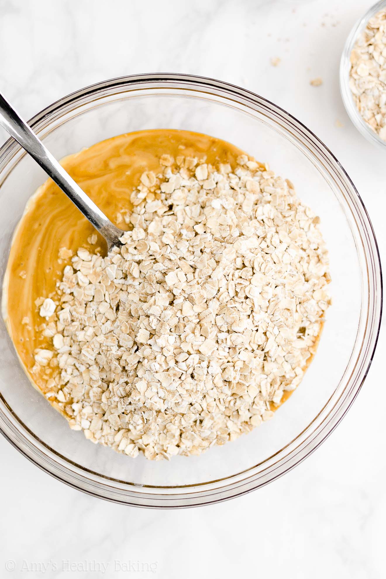 glass mixing bowl holding some of the ingredients used to make a healthy oatmeal gingerbread loaf – easy gingerbread quick bread recipe – soft, moist, low fat, low calorie, and clean eating with whole wheat and gluten free options – made with oats, Greek yogurt, molasses, and no refined sugar