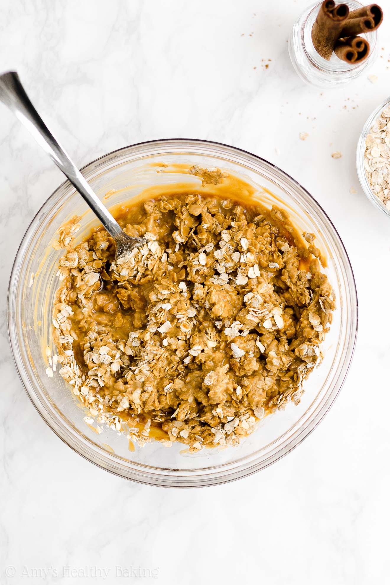 glass mixing bowl holding partially stirred oats, molasses, and Greek yogurt that will be used to make a healthy oatmeal gingerbread loaf – easy gingerbread quick bread recipe – soft, moist, low fat, low calorie, and clean eating with whole wheat and gluten free options – made with oats, Greek yogurt, molasses, and no refined sugar
