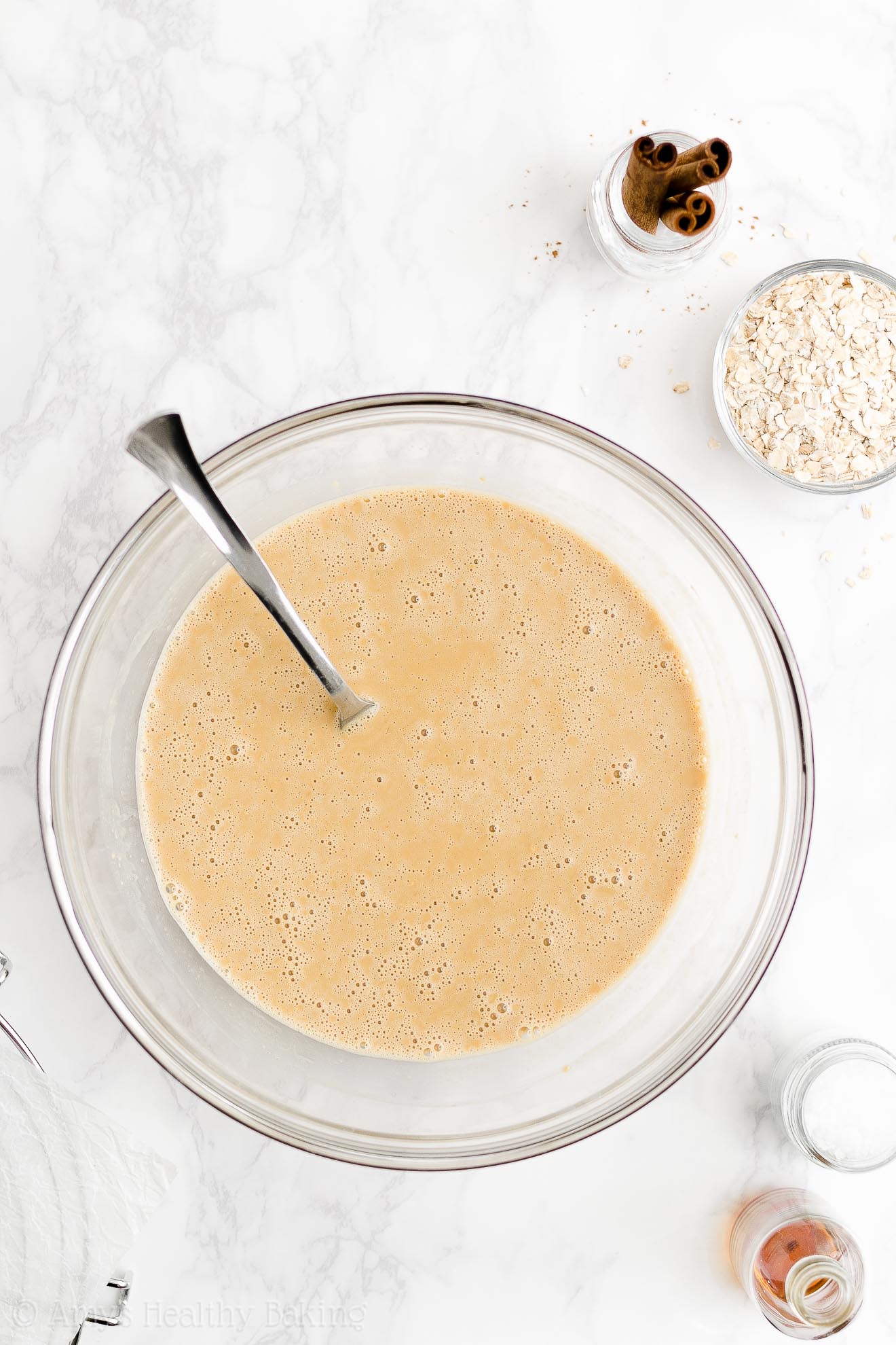 glass mixing bowl holding the wet ingredients used to make a healthy oatmeal gingerbread loaf – easy gingerbread quick bread recipe – soft, moist, low fat, low calorie, and clean eating with whole wheat and gluten free options – made with oats, Greek yogurt, molasses, and no refined sugar