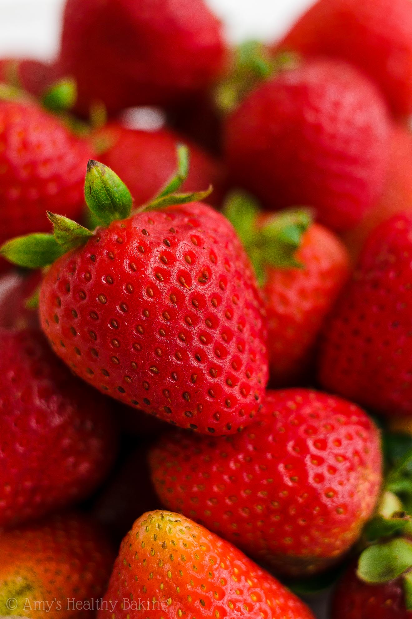 fresh whole strawberries, about to be turned into healthy strawberry oatmeal breakfast cookies – easy strawberry breakfast cookies recipe – soft, chewy, low calorie, low fat, and clean eating with whole wheat, gluten free, dairy free, and nut free options – made with oats, fresh strawberries, pure maple syrup, and no refined sugar