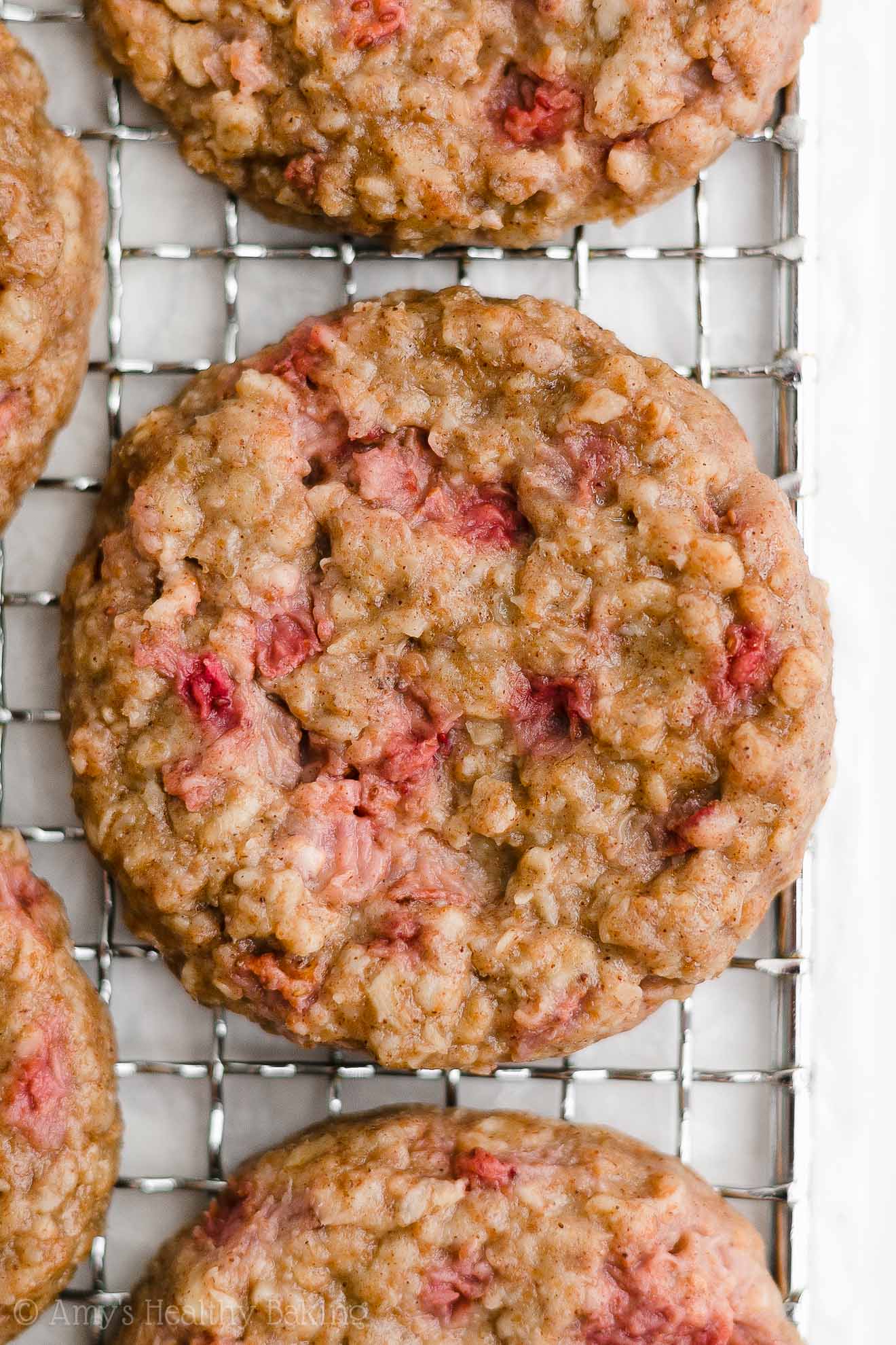 healthy strawberry oatmeal breakfast cookies on a wire cooling rack – easy strawberry breakfast cookies recipe – soft, chewy, low calorie, low fat, and clean eating with whole wheat, gluten free, dairy free, and nut free options – made with oats, fresh strawberries, pure maple syrup, and no refined sugar
