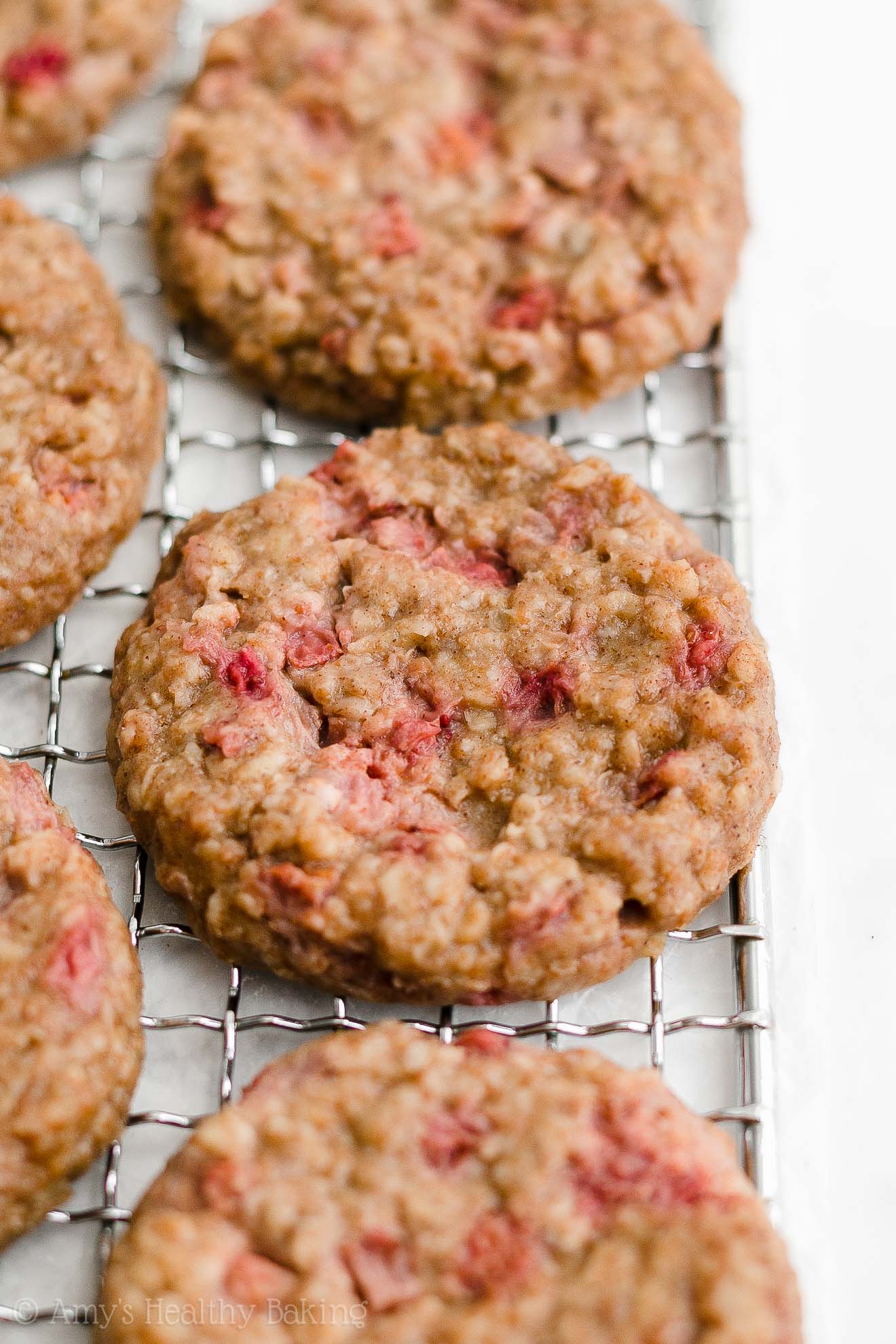 healthy strawberry oatmeal breakfast cookies on a rectangular wire cooling rack – easy strawberry breakfast cookies recipe – soft, chewy, low calorie, low fat, and clean eating with whole wheat, gluten free, dairy free, and nut free options – made with oats, fresh strawberries, pure maple syrup, and no refined sugar